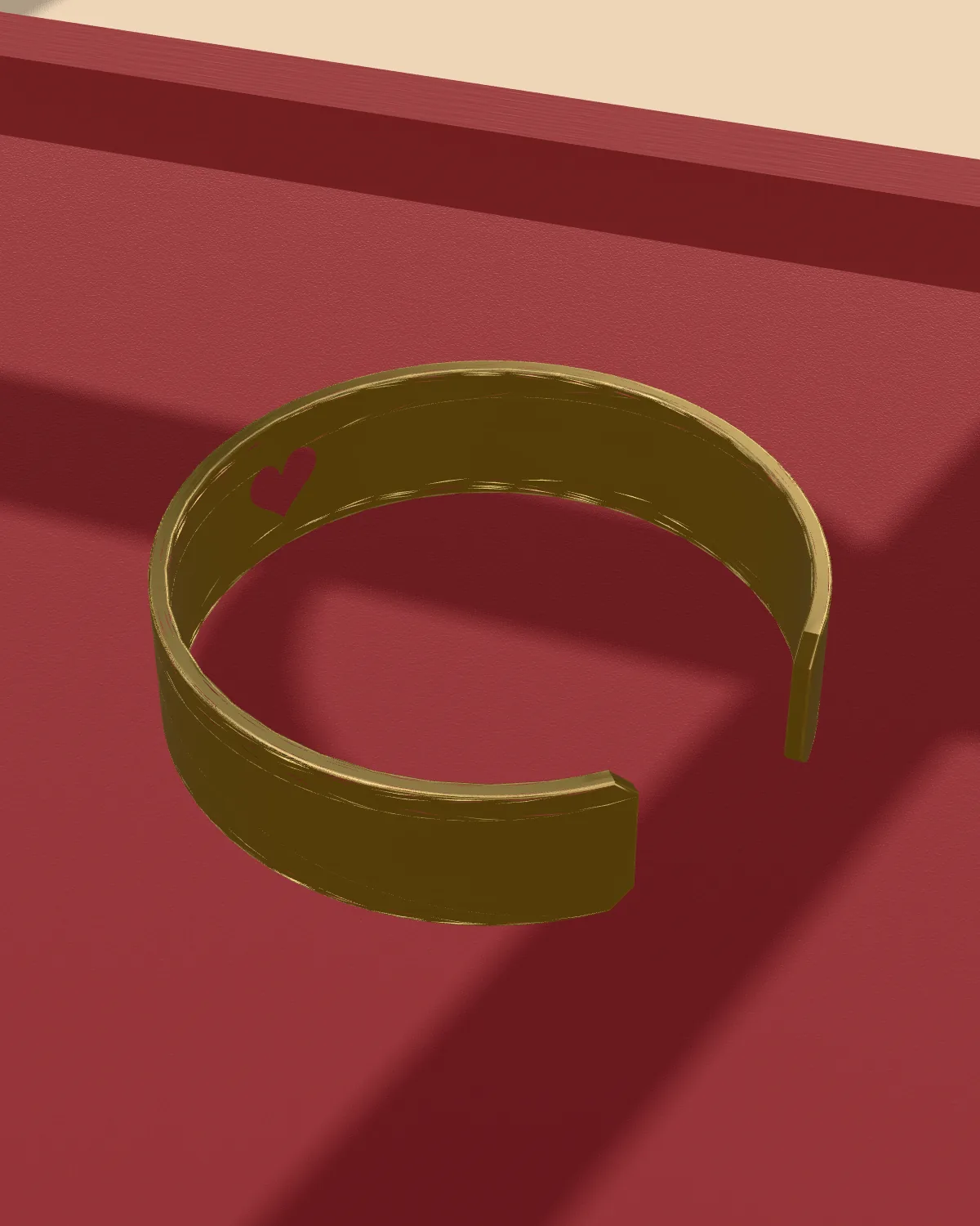 Brass cuff with a heart cutout, laid flat on velvet
