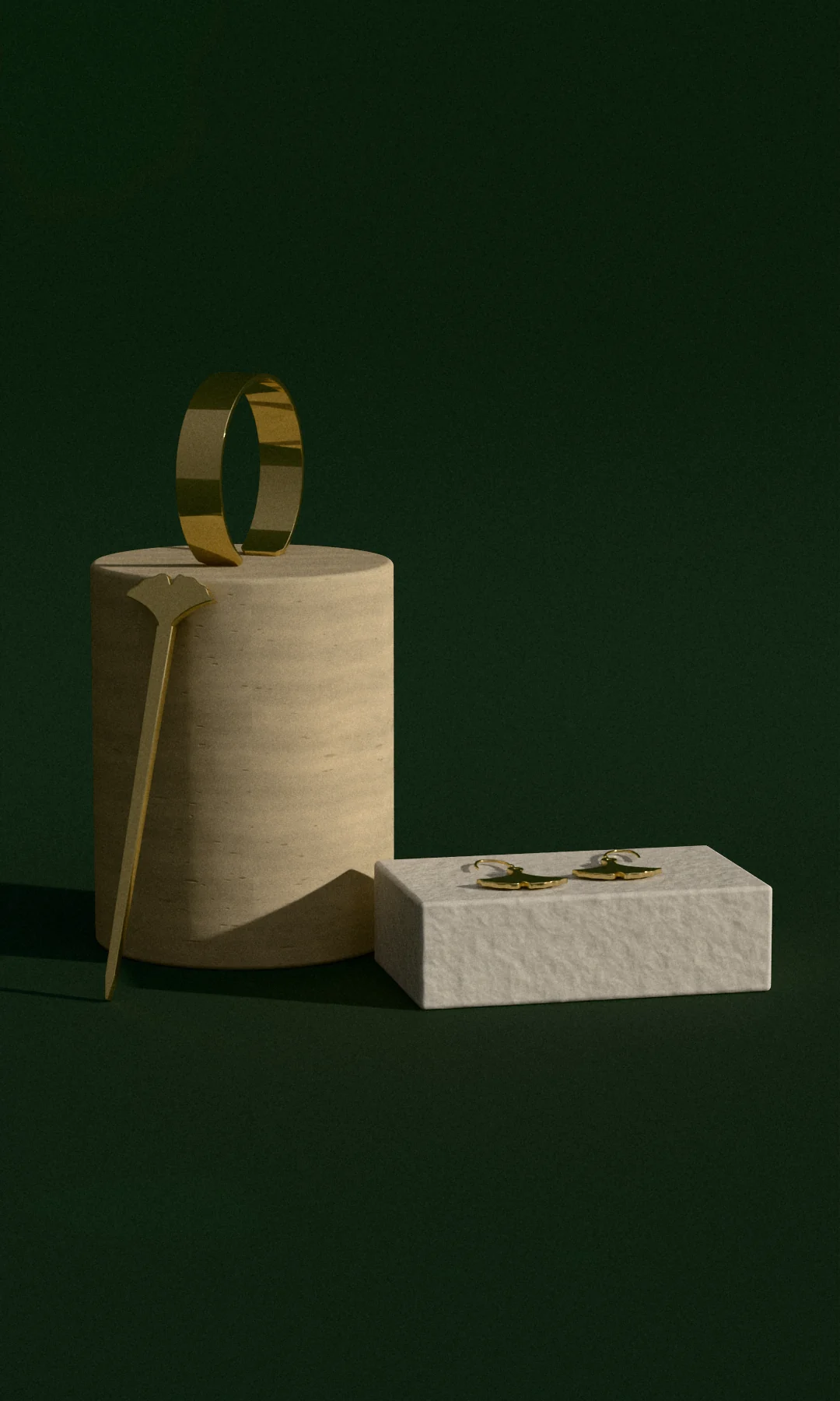 A brass cuff on a travertine drum with a hair stick leaning against it, and ginkgo earrings on a plaster block, in low sun against green paper
