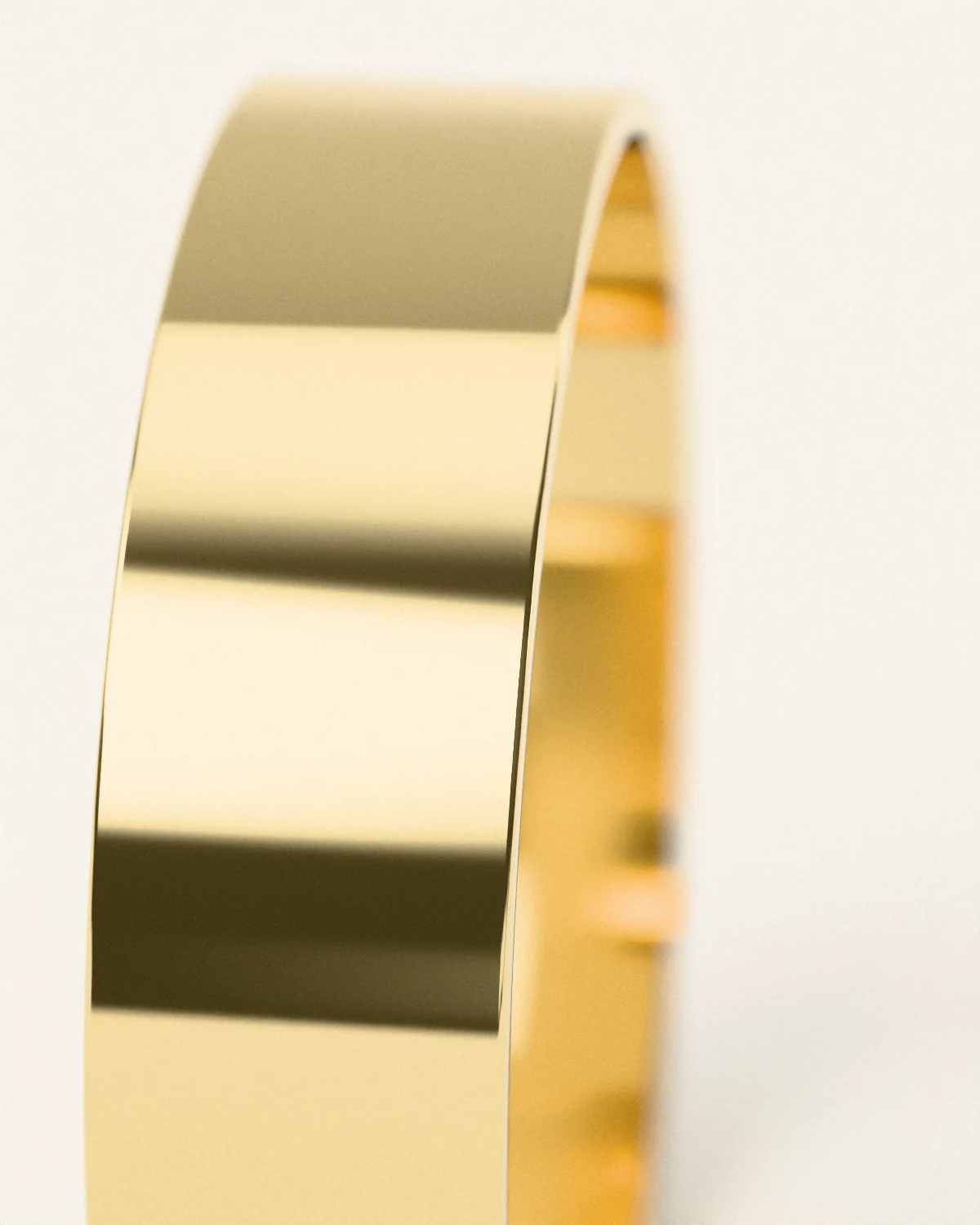 The polished edge of a hand-formed brass cuff, close