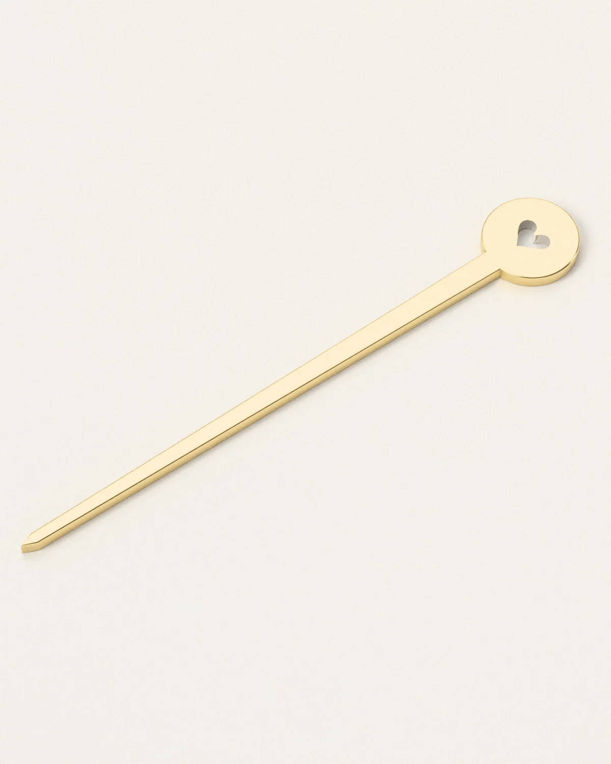 Brass hair stick, laid flat on pale paper